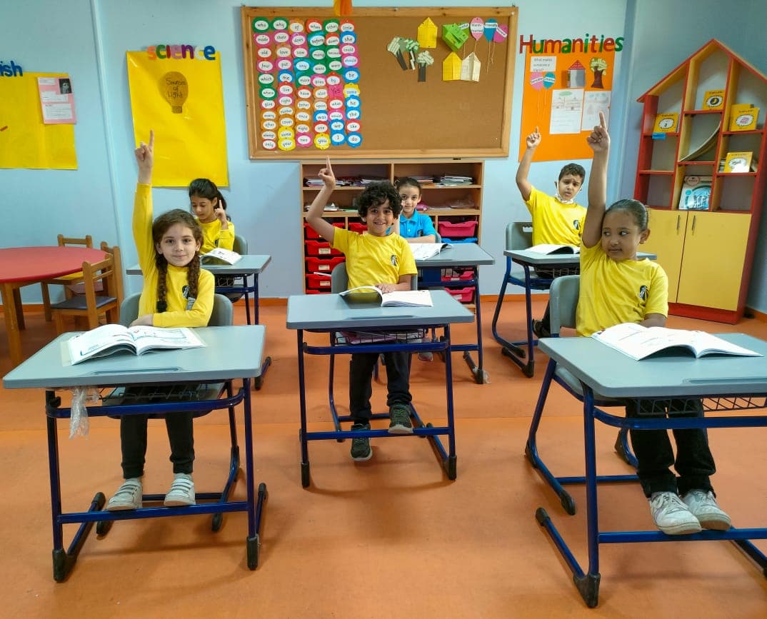 Students raising their hands in class